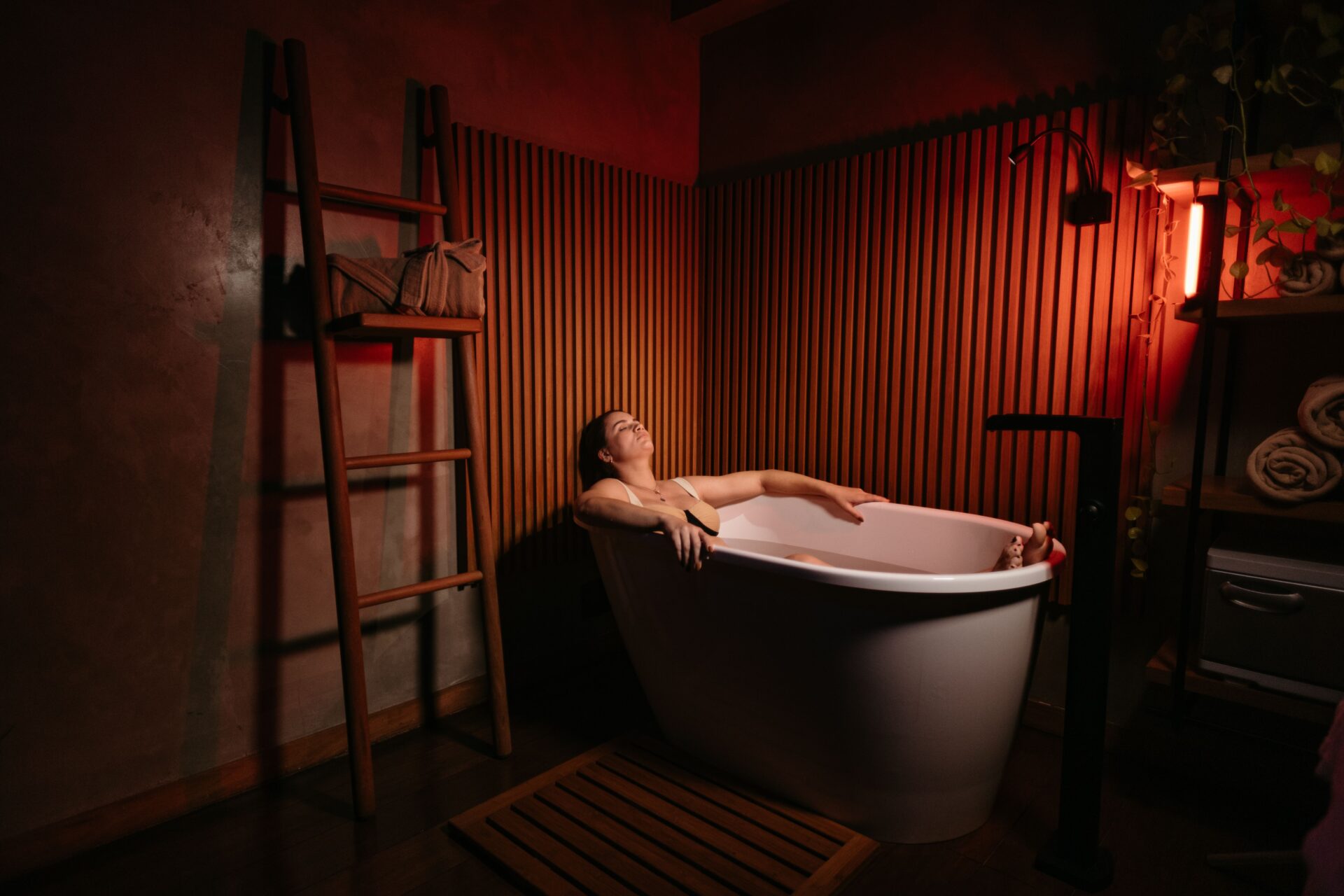Woman relaxing in a freestanding bathtub as part of a biohacking and wellness routine